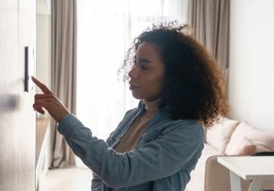 woman adjusting thermostat